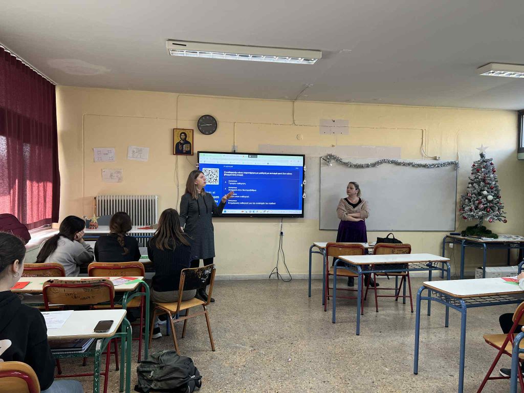 Δύο στελέχη της Μονάδας  συνομιλούν με μαθητές και μαθήτριες κατά τη διάρκεια της δράσης. 